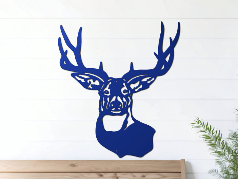 Blue deer head metal wall art hangs on a white wall above a wooden bench
