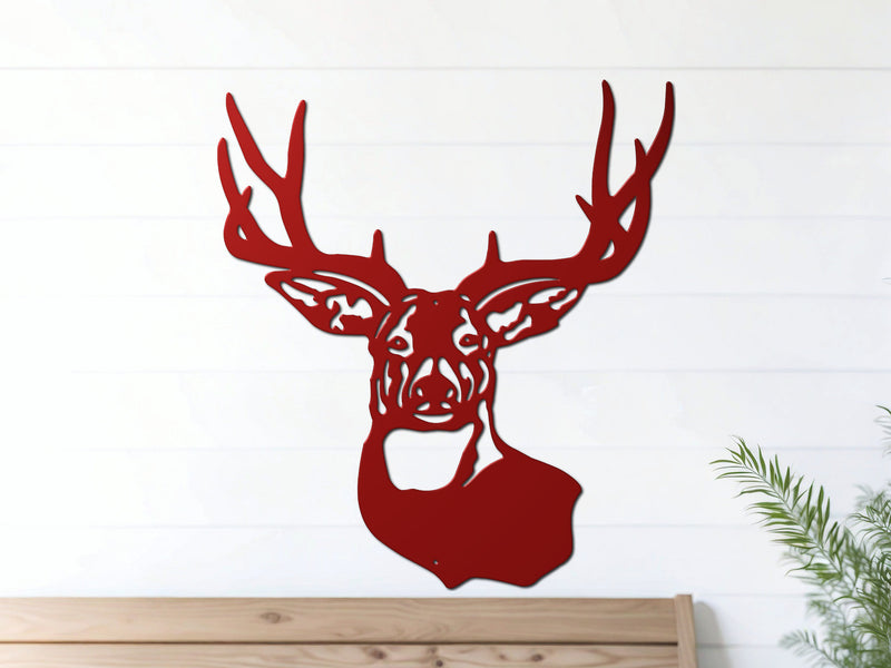 Red deer head metal wall art hangs on a white wall above a wooden bench